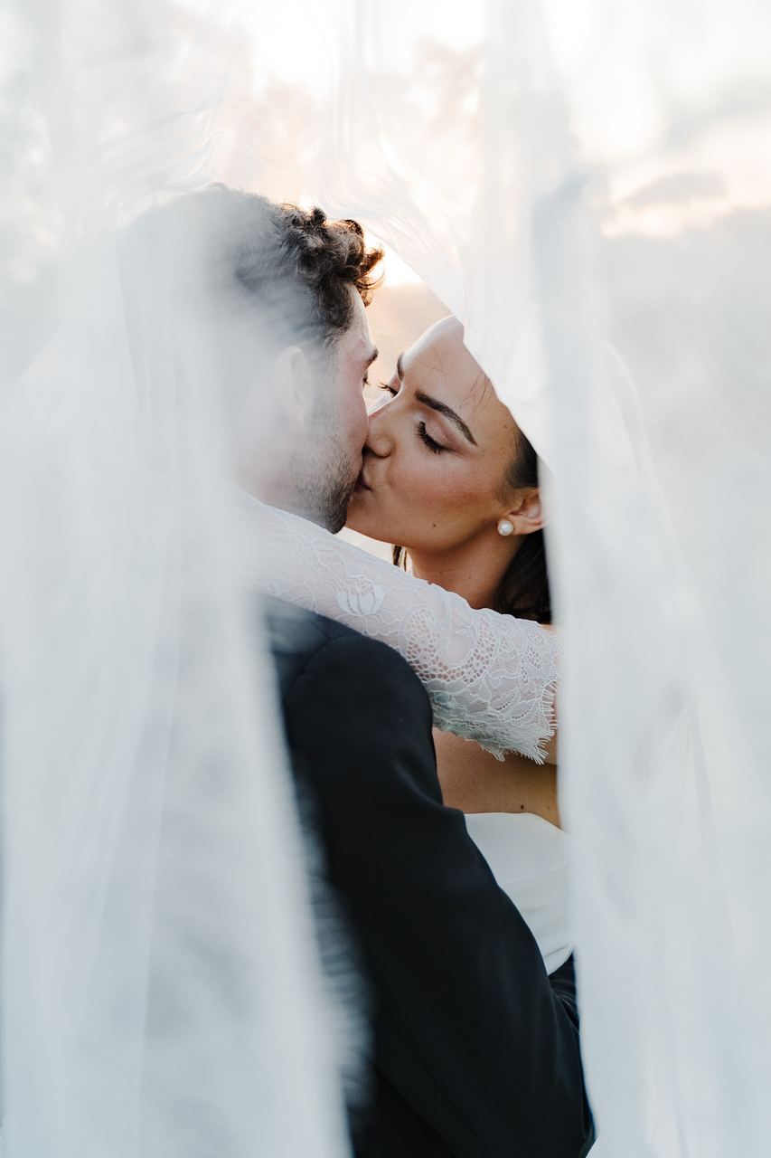 Ben and Cameron kissing beneath the veil
