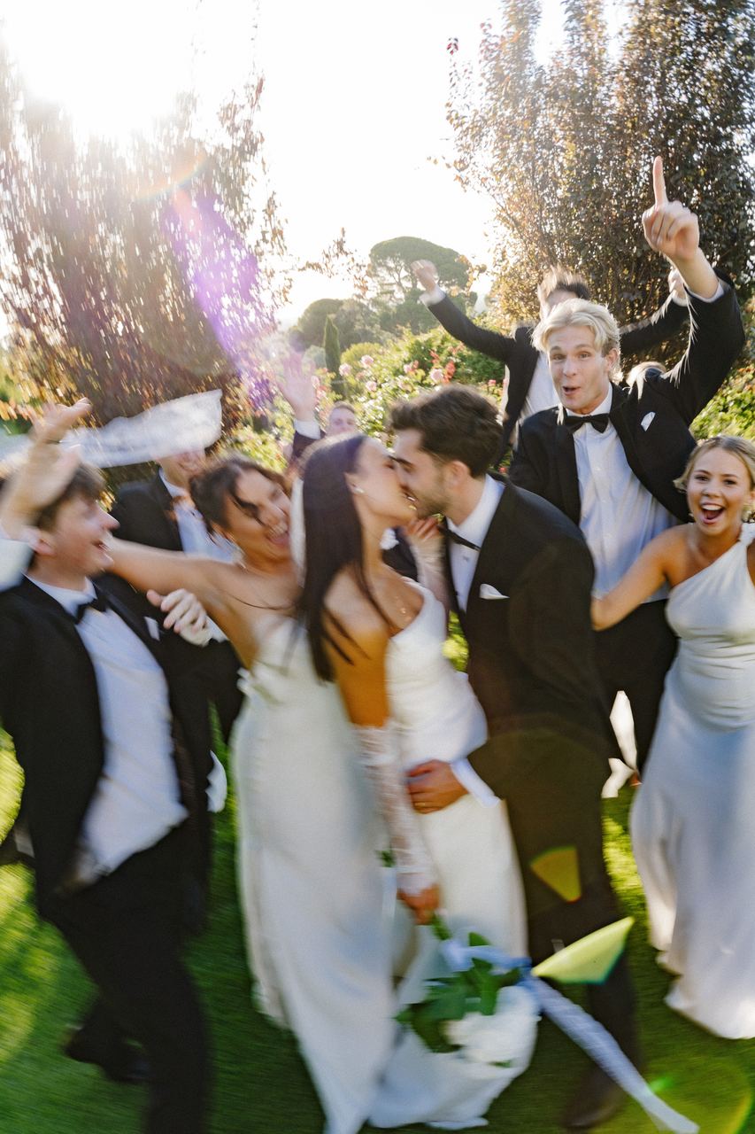 The wedding party cheering as Ben and Cameron kiss