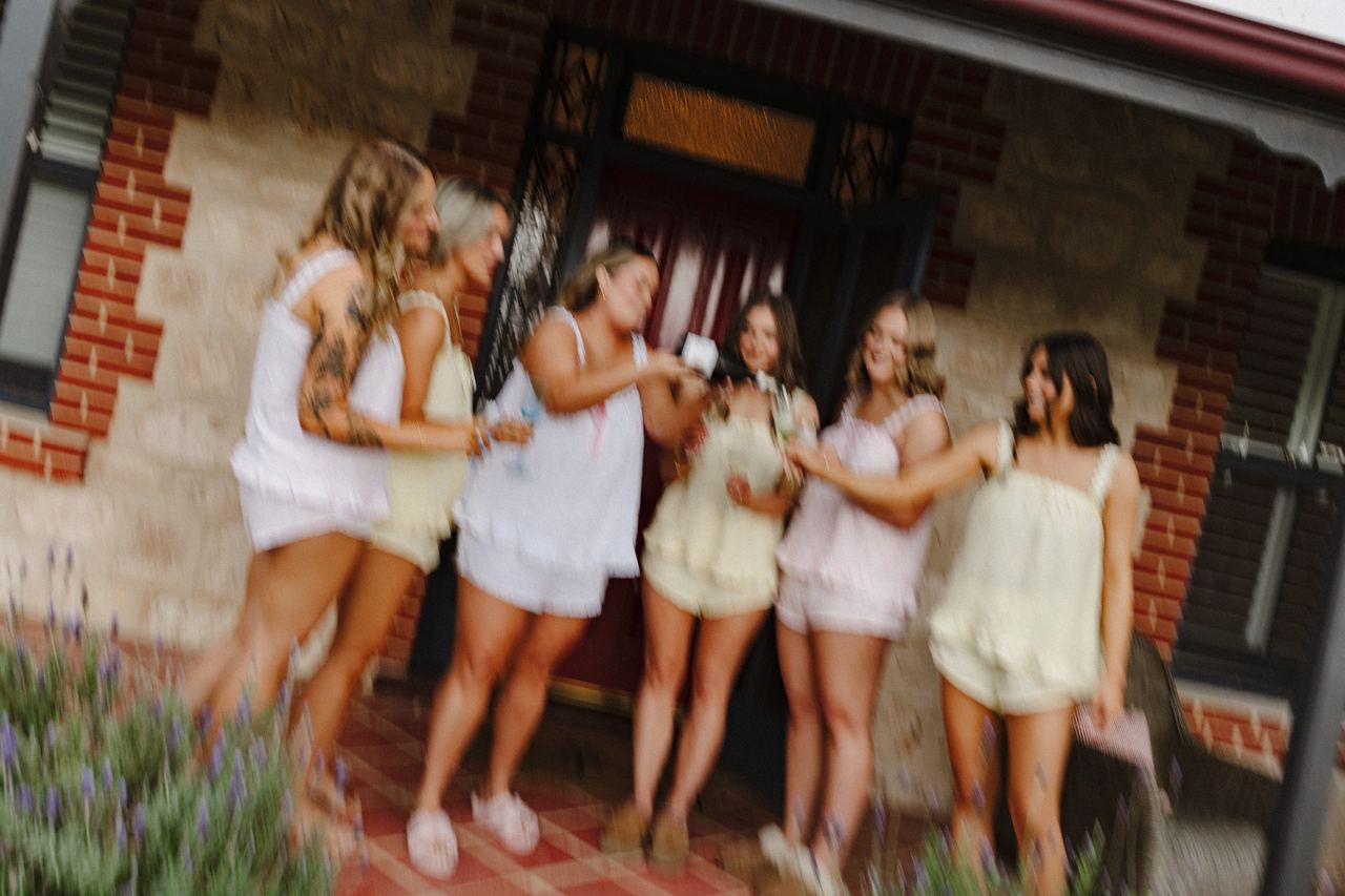 The bridesmaids popping champagne at the front door