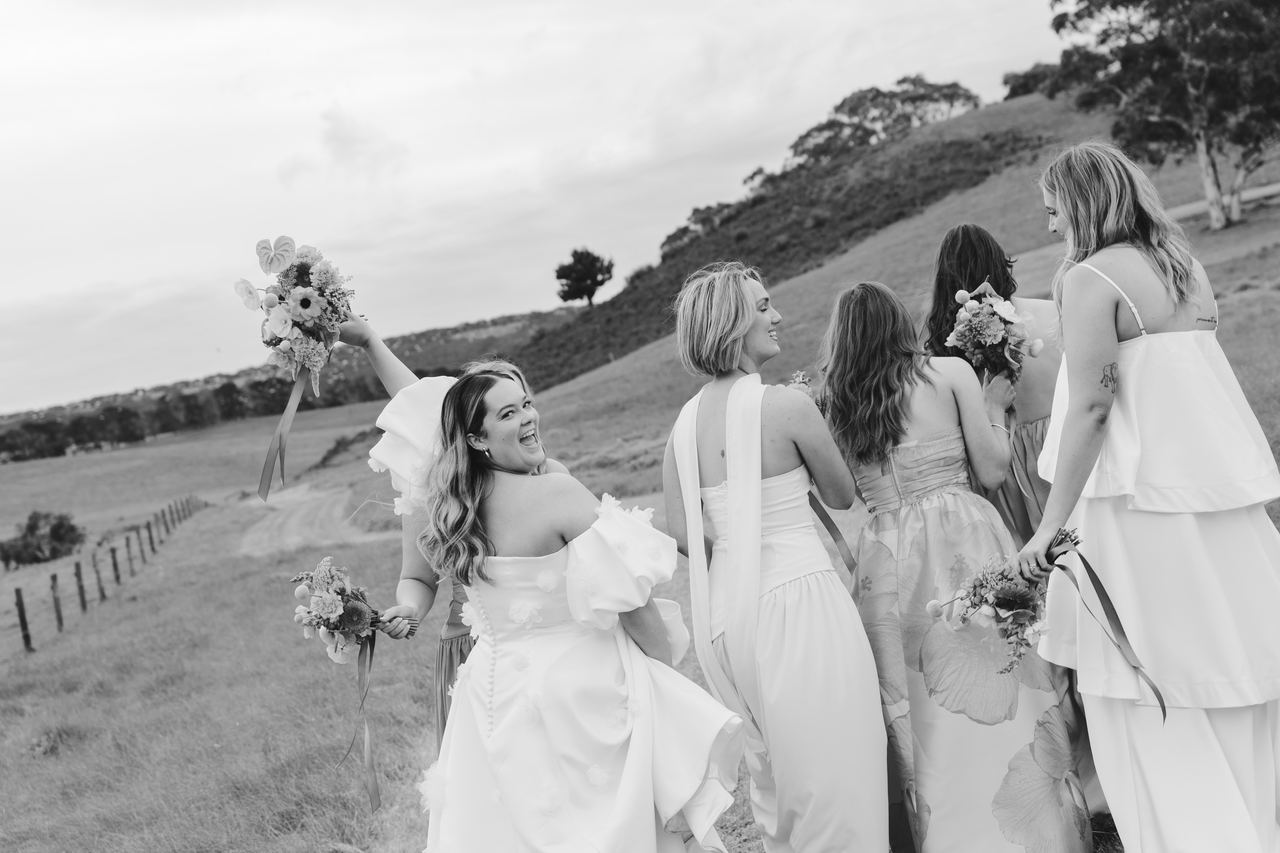 The bridesmaids walking through the paddock, bouquets in the air