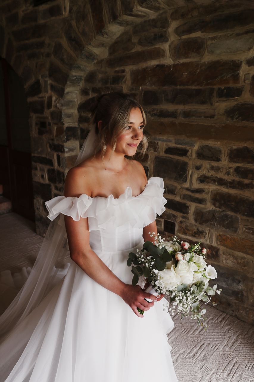 Lily by the window, holding the bouquet