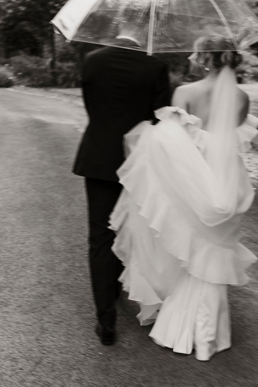 Jason and Lily walking together under an umbrella