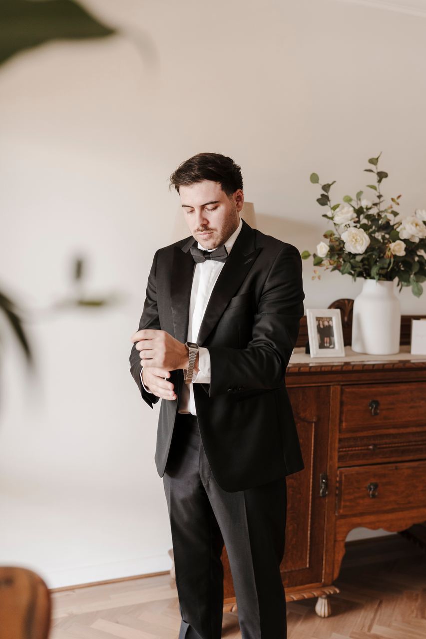 Ben fixing a cufflink by the window