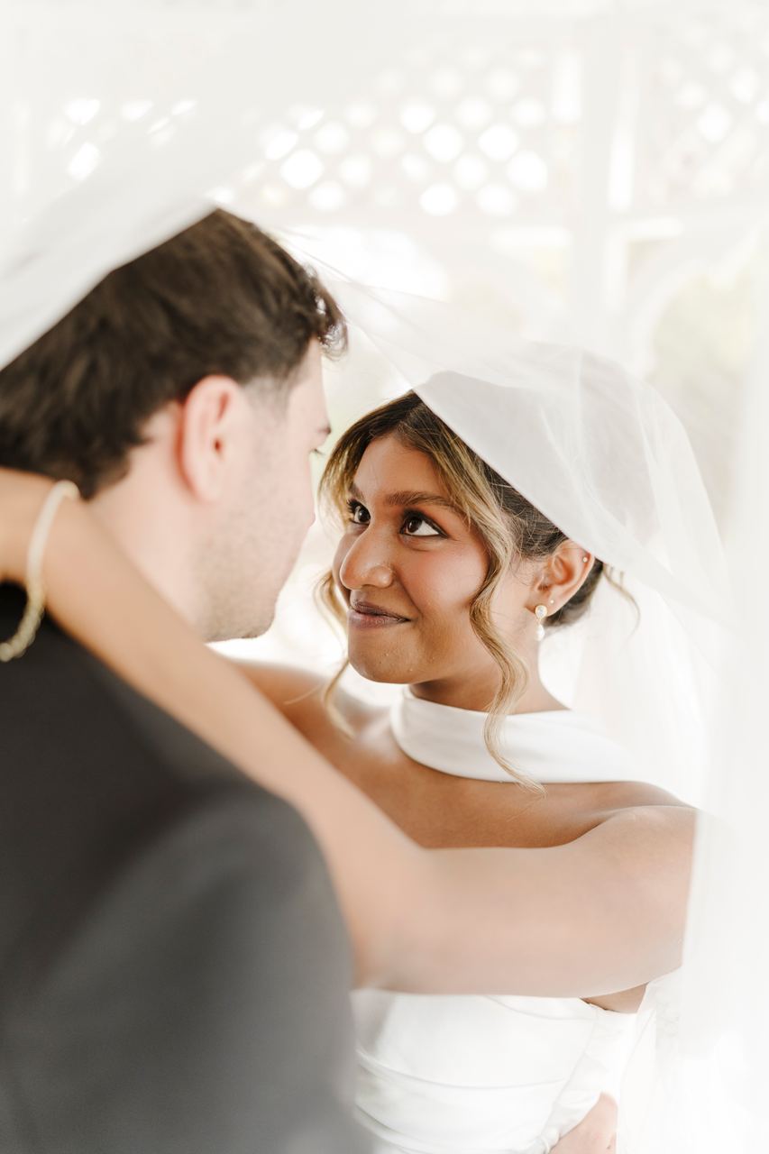 Sinead smiling up at Ben beneath the veil