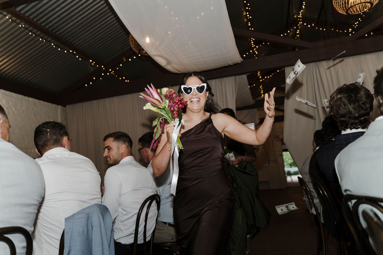 A guest dancing with the bouquet at the reception