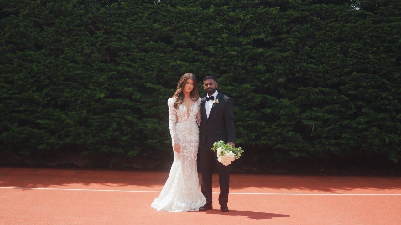 Nathan and Annabella standing together in front of a tall hedge