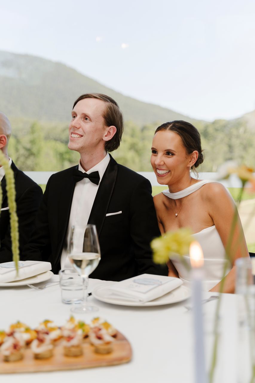 Matthew and Alex laughing at the reception table