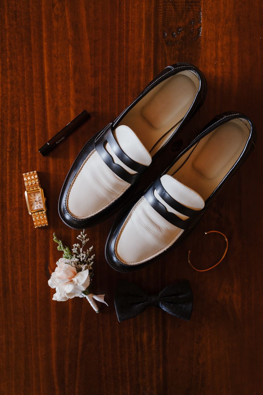 Liam's loafers, watch and buttonhole laid out on timber
