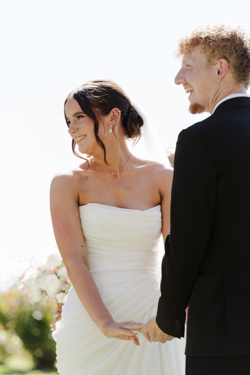 Emma and Liam smiling at each other during the ceremony