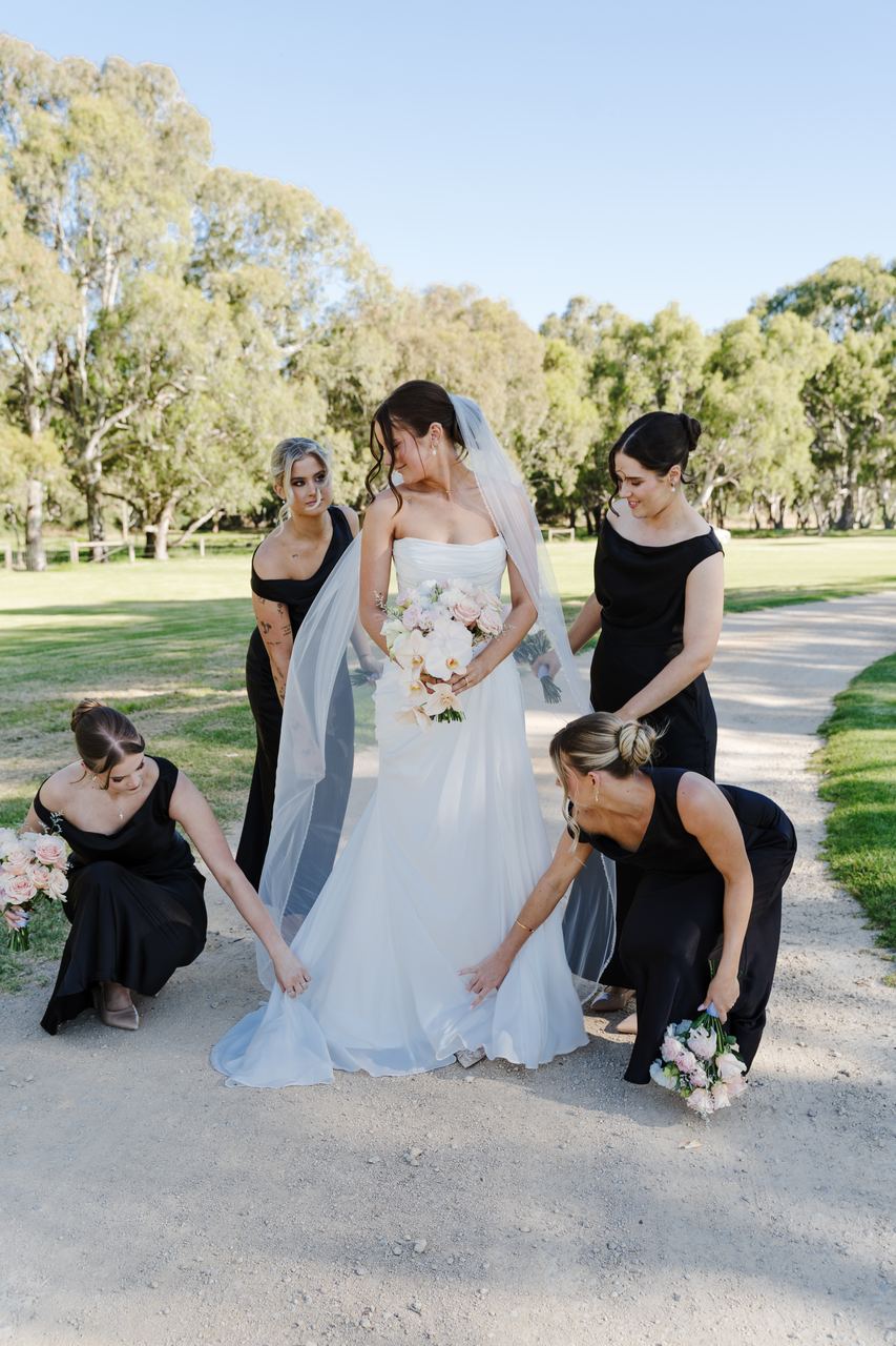 The bridesmaids fixing Emma's dress