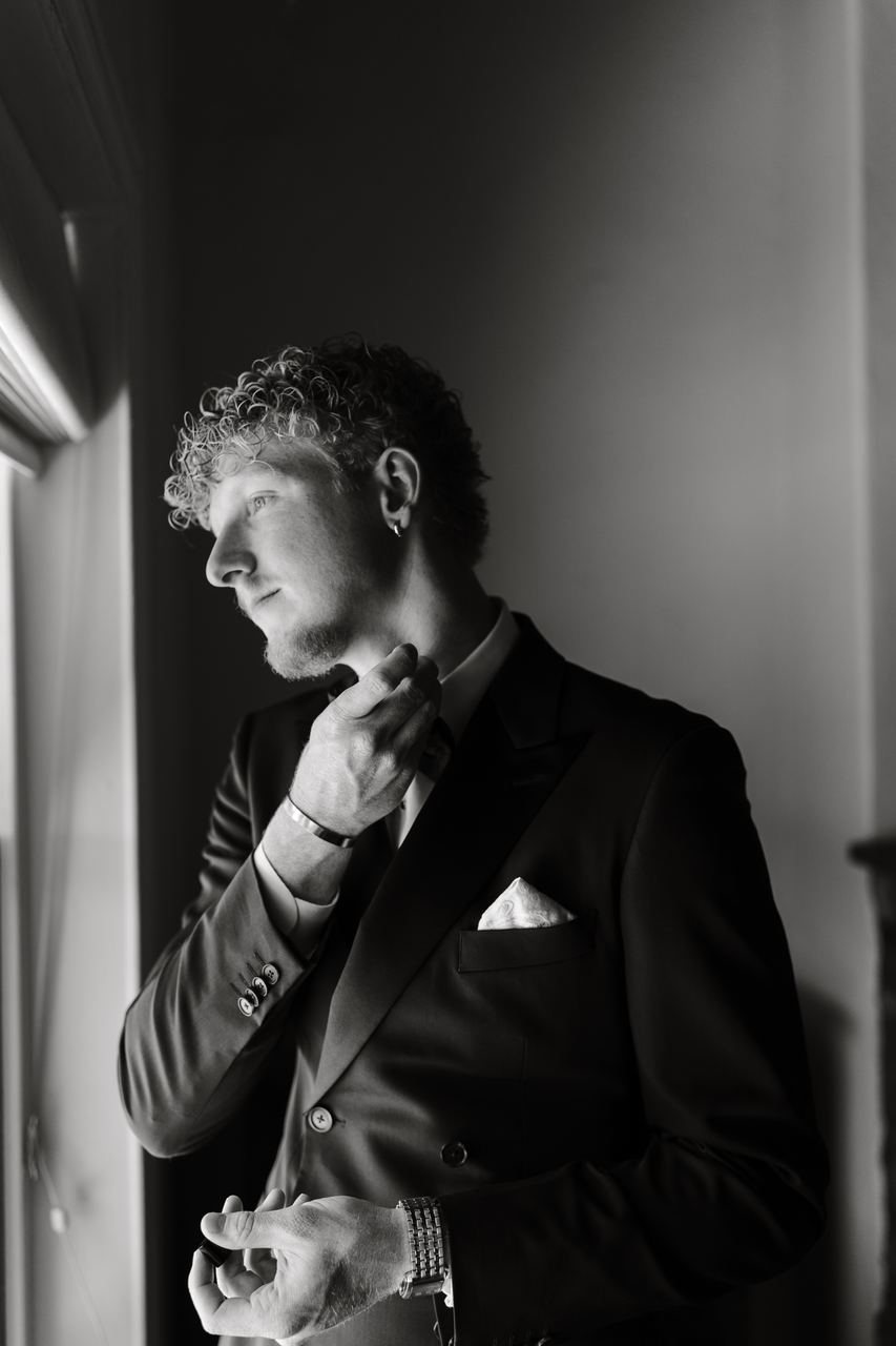 Liam adjusting a collar by the window