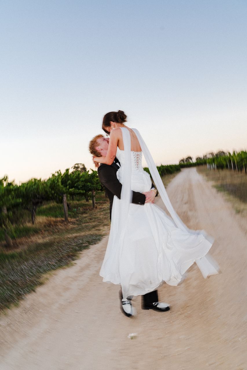 Liam lifting Emma on the vineyard track
