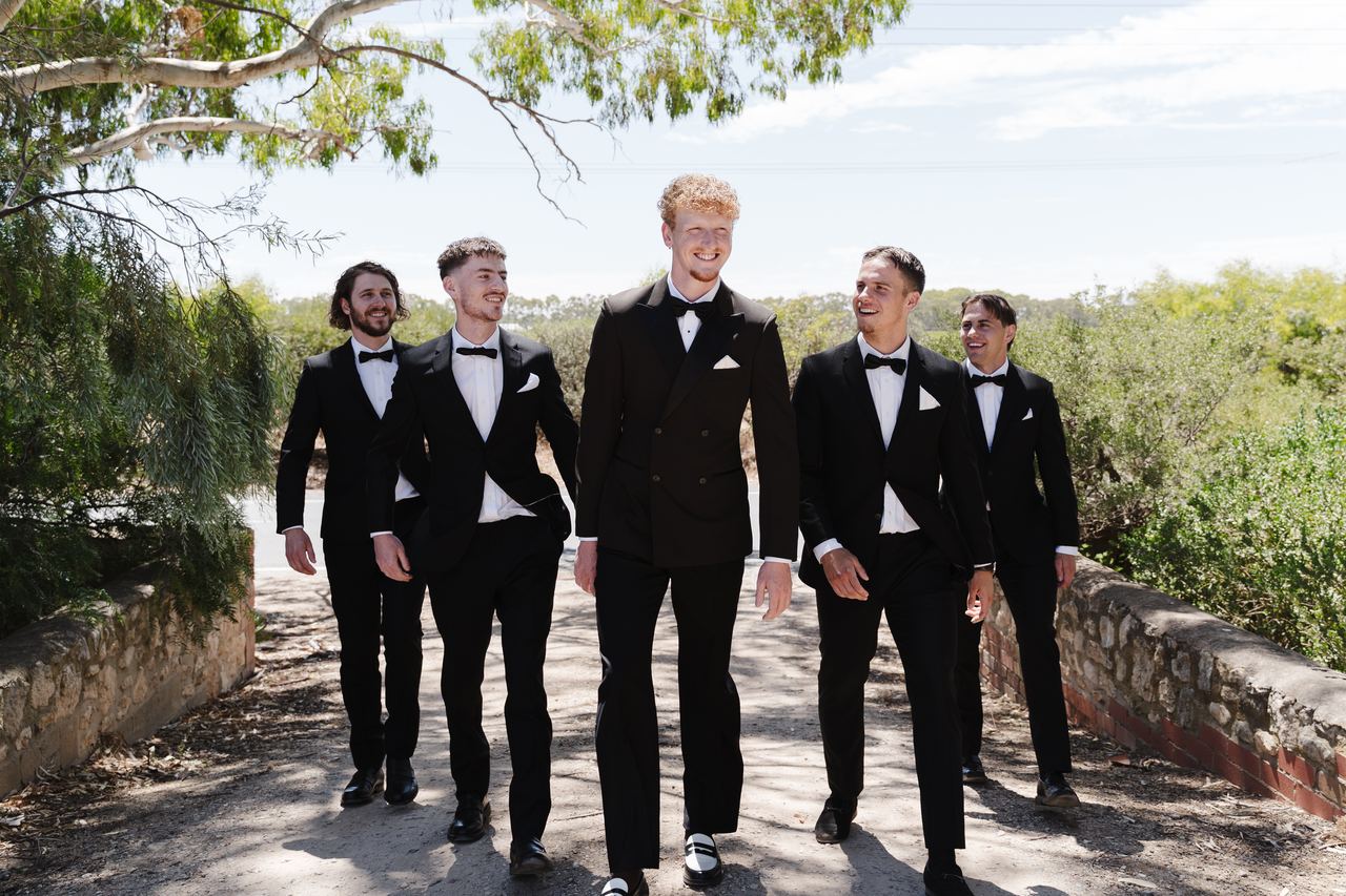 Liam and the groomsmen walking down the path