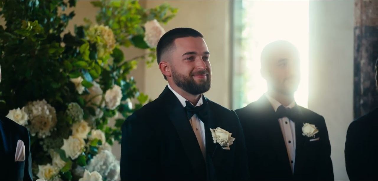 Fin smiling at the altar as the ceremony begins