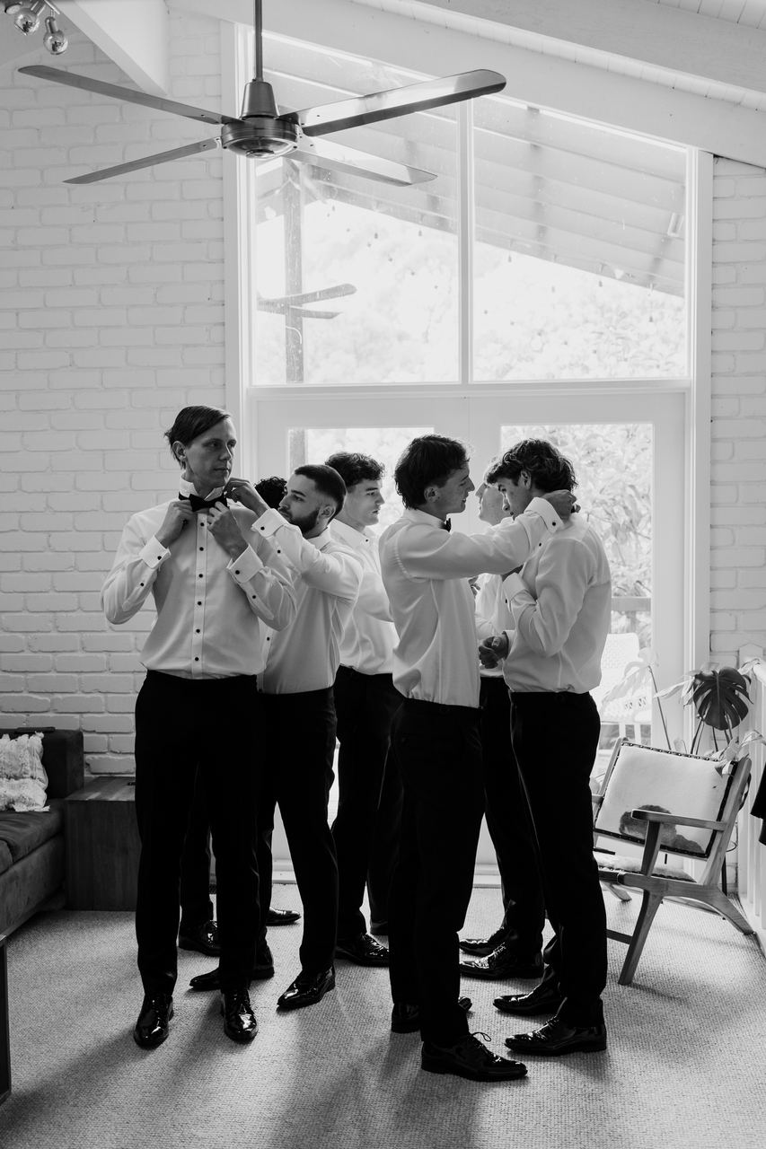 The groomsmen fixing their bow ties