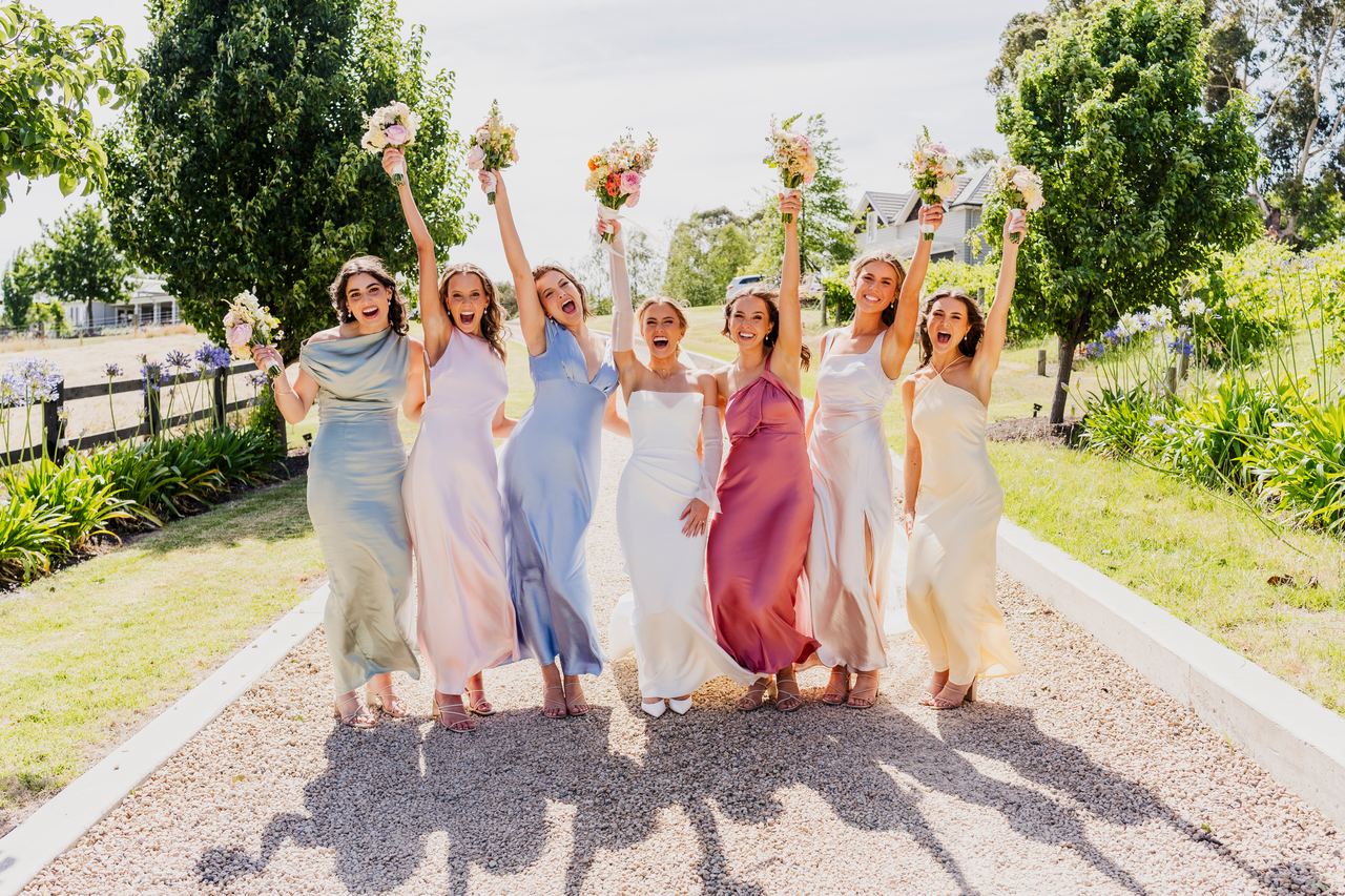 The bridesmaids raising their bouquets