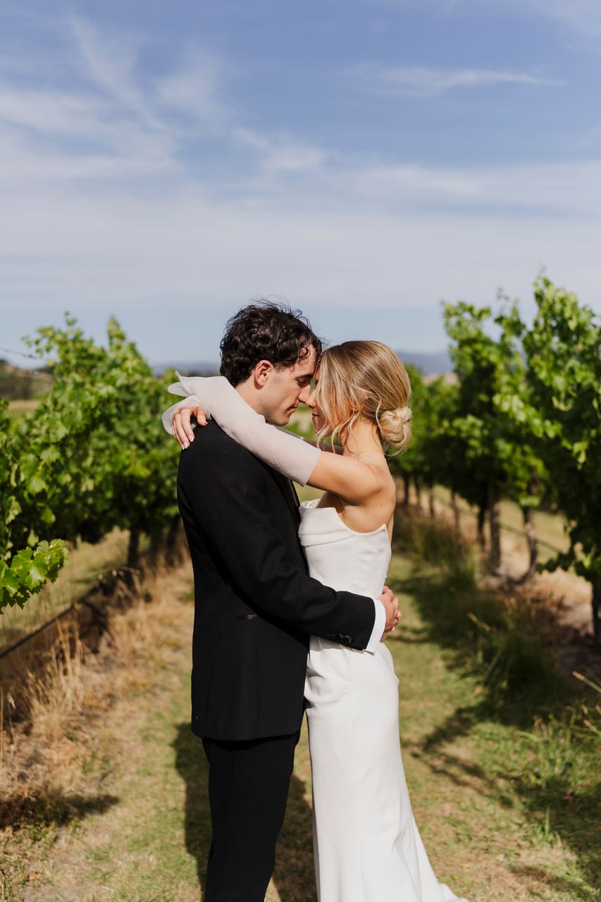Caleb and Georgia embracing among the vines