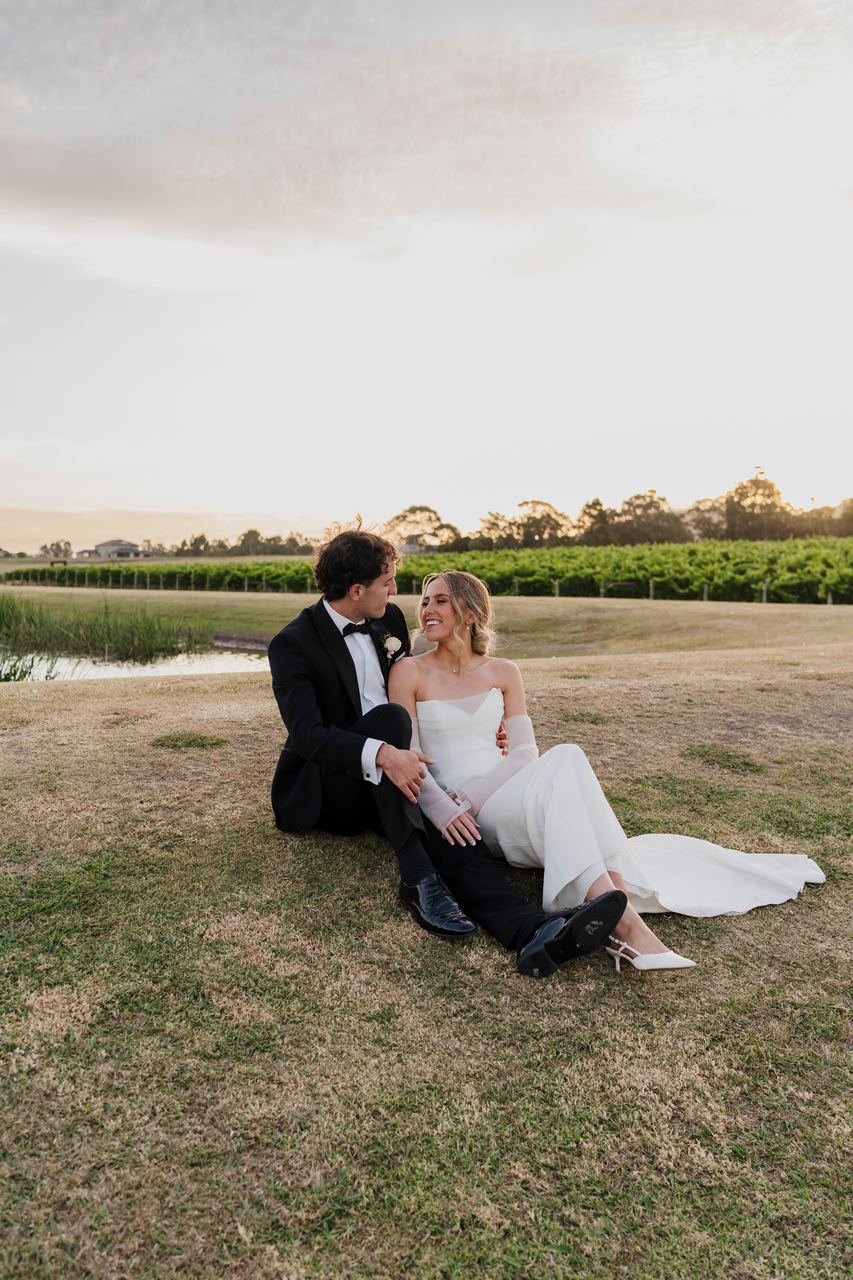 Caleb and Georgia sitting together in the vineyard