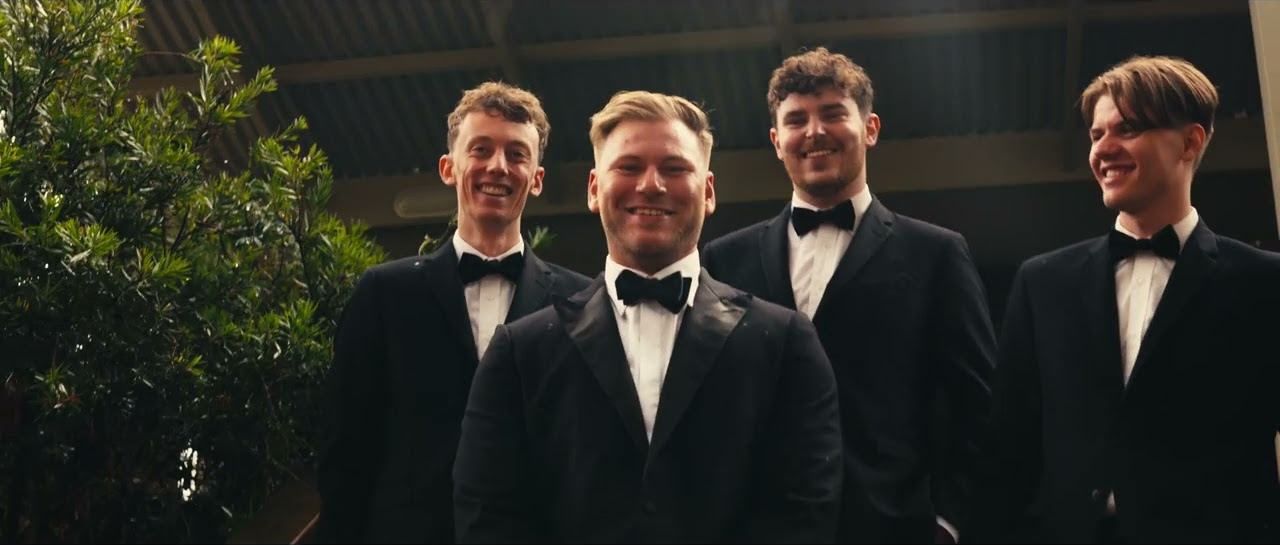 Kaleb and the groomsmen smiling down at the camera